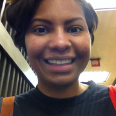 Headshot photo of Monae smiling at the camera